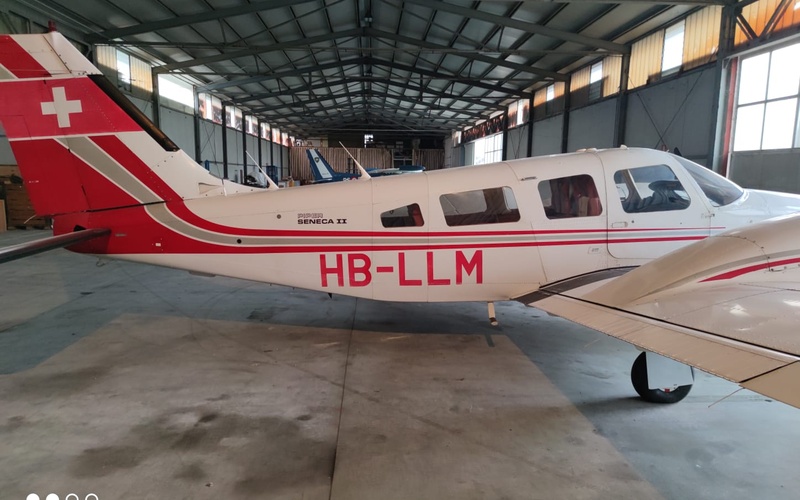 Sigla HB-LLM applicata sulla fiancata di un aeroplano bimotore all’interno di un hangar