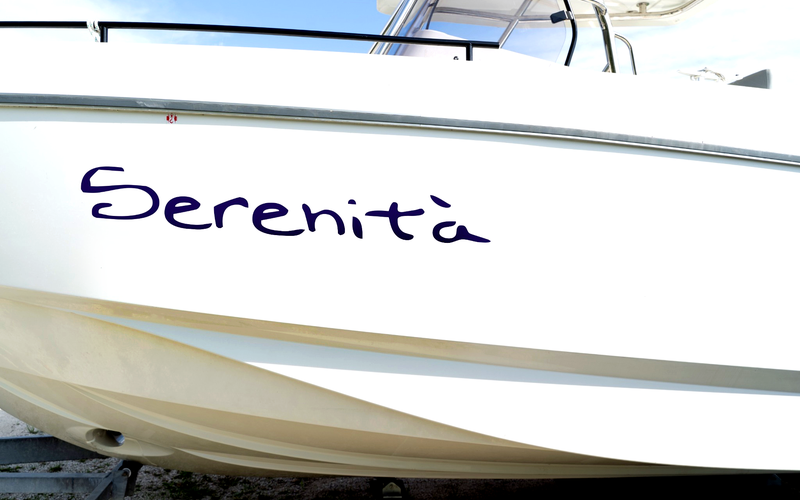 Nome barca Serenità in blu su fiancata di barca bianca